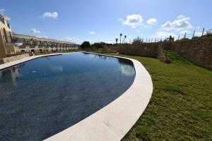 a swimming pool in a yard next to a building at Hal Wardija - Gozo Hideaways in Qala