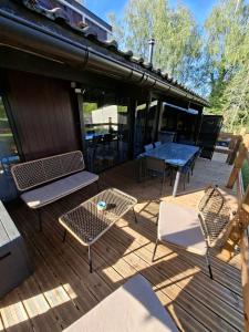 eine Terrasse mit Stühlen und einem Tisch sowie ein Tisch und Stühle in der Unterkunft Chalet douceur in Virton