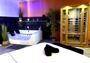 a bathroom with a tub and a bed in a room at Spacieux spa et sauna in Bourges +44 photos