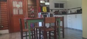a kitchen with a bar with chairs and a counter top at Quinta la ponderosa in Brandsen
