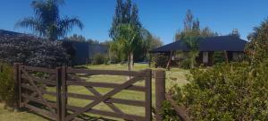 a wooden fence in front of a house at Quinta la ponderosa in Brandsen
