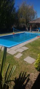a swimming pool with a volley ball net in a yard at Quinta la ponderosa in Brandsen +14 photos