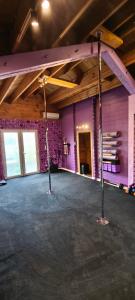 a large room with purple walls and a stage at Flyby pole studio in Béziers