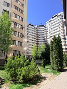 a group of trees in front of a building at New House Strișca in Chişinău