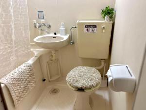a small bathroom with a toilet and a sink at 眠りの癒201 I Cozy Apt, 3min Beach, Bus, Train, Onsen, Izakaya, WiFi in Beppu +17 photos