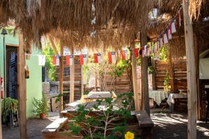 a patio with a table and a straw umbrella at Astro Camping Elqui Experience in Vicuña +33 photos