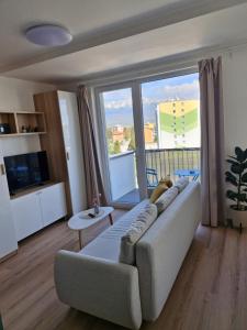 a living room with a couch and a large window at Apt 415 Svit in Jezersko