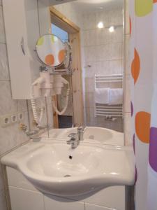 a bathroom with a white sink and a mirror at Haus Orleander in Rehgraben