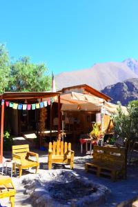 a building with chairs and a fire in front of it at Astro Camping Elqui Experience in Vicuña