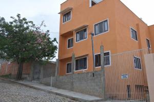 an orange building with a fence in front of it at Studio prático e tranquilo em Jacobina in Jacobina