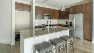 a kitchen with a counter with stools and a refrigerator at Landing Incredible 2BD Gym in New Caney