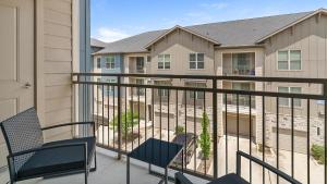 a balcony with two chairs and a building at Landing Incredible 2BD Gym in New Caney