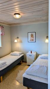 a bedroom with two beds and a dog picture on the wall at Gammal björn in Dalskog