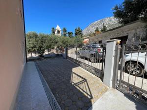 a driveway with a gate and a car parked next to a building at sunny Podaca in Podaca