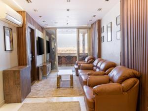 a living room with leather couches and a flat screen tv at Shiny Pyramids Boutique Hotel in Cairo