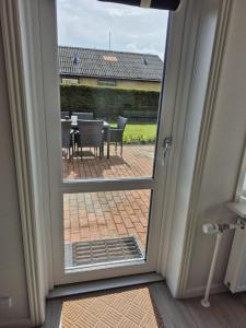 a door leading to a patio with a table and chairs at Annes Hus in Rødekro