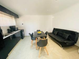 a living room with a black couch and a table at FlowithLin Guesthouse in Durban