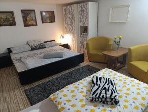 a bedroom with a bed and two chairs and a table at Apartman Emma in Visoko
