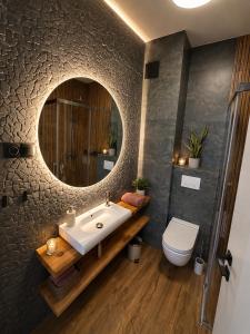 a bathroom with a sink and a toilet and a mirror at Vistula Apartment in Ustroń +22 photos