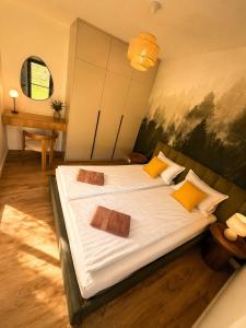 a bedroom with a large bed with white sheets and yellow pillows at Vistula Apartment in Ustroń