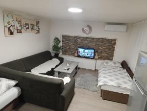 a living room with a couch and a tv at Apartman Emma in Visoko