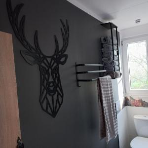 a wall with a deer head on a bathroom wall at Jeziorskie Zacisze & balia in Łyszkowice +58 photos