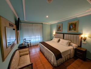 a bedroom with a bed and a couch in it at Hotel Boutique El Pescador in Cudillero