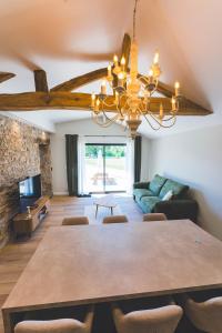 a dining room with a table and a couch at Gîte de La Sulpicière - avec clim in Cholet