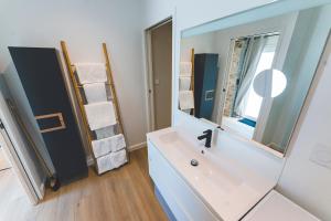 a bathroom with a sink and a mirror at Gîte de La Sulpicière - avec clim in Cholet
