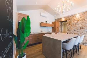 a kitchen and dining room with a stone wall at Gîte de La Sulpicière - avec clim in Cholet +6 photos