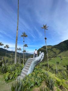 a man standing on top of a giant hand statue at Posada Martha Tolima in Salento