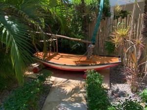 a boat sitting in a garden next to a fence at Oasis Tropical in Paracuru