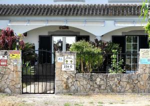 a house with a gate with signs on it at Sandra B&B in Luz de Tavira