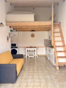 a living room with a loft bed and a table at Anisades, Maison cosy avec jardin 5 min plage in Le Barcarès