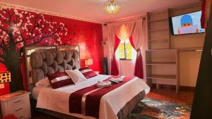 a bedroom with a bed with a red wall at Posada Martha Tolima in Salento