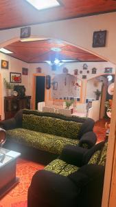 a living room with two couches and a table at Posada Martha Tolima in Salento