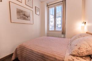 a bedroom with a bed and a window at Appartement Centre Cauterets Calme, Confort, wifi et linge de maison inclus in Cauterets