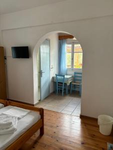 a bedroom with a bed and a dining room with a table at Faros Rooms Armenistis in Armenistis