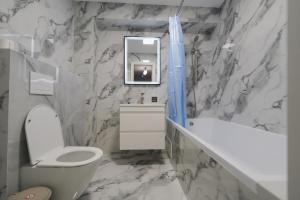 a bathroom with a toilet and a sink and a tub at Kogălniceanu 23 in Căuşeni +17 photos
