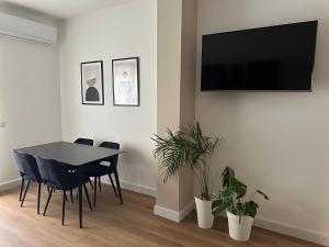 ein Esszimmer mit einem Tisch und einem Fernseher an der Wand in der Unterkunft Domus Ale in Vallo della Lucania
