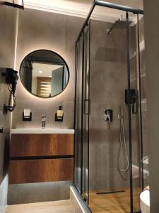 a bathroom with a shower and a sink and a mirror at NK Loft in Alexandroupoli