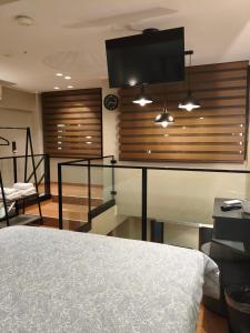 a bedroom with a bed and a flat screen tv at NK Loft in Alexandroupoli