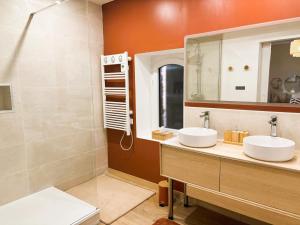 a bathroom with two sinks and a mirror at Le cottage du Breil in Verfeil