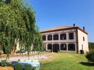 a house with a table and chairs in front of it at Le cottage du Breil in Verfeil
