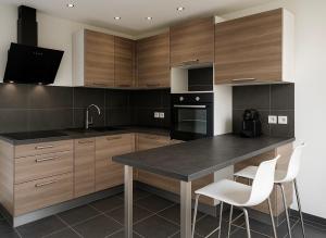 a kitchen with wooden cabinets and a black counter top at Les vacances in Sainte-Maxime +24 photos