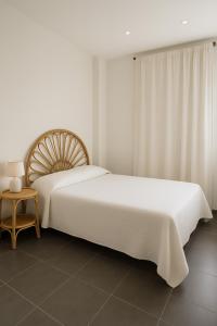 a white bedroom with a large bed and a table at Les vacances in Sainte-Maxime