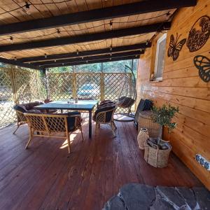 a patio with a table and chairs on a wooden deck at Jeziorskie Zacisze & balia in Łyszkowice