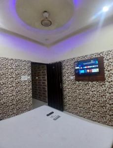 a room with a flat screen tv on a wall at Agam Homestay - Few Steps From golden temple in Amritsar +41 photos