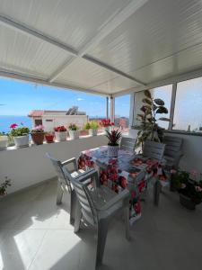 a table and chairs on a balcony with plants at Summerland Lukovë in Sarandë