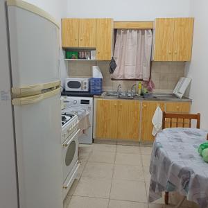 a kitchen with a refrigerator and a stove top oven at Vocation Rest House in Anogyra in Anoyira